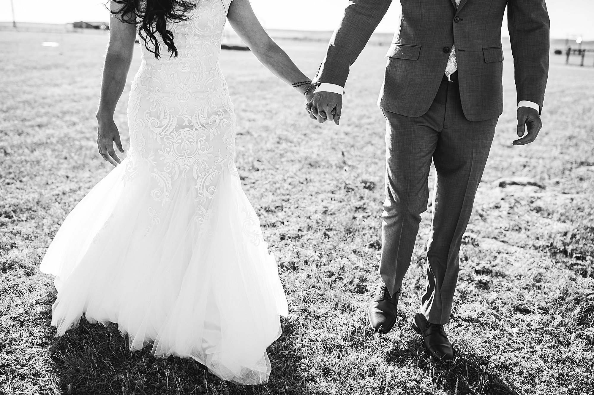 bride groom holding hands prairie